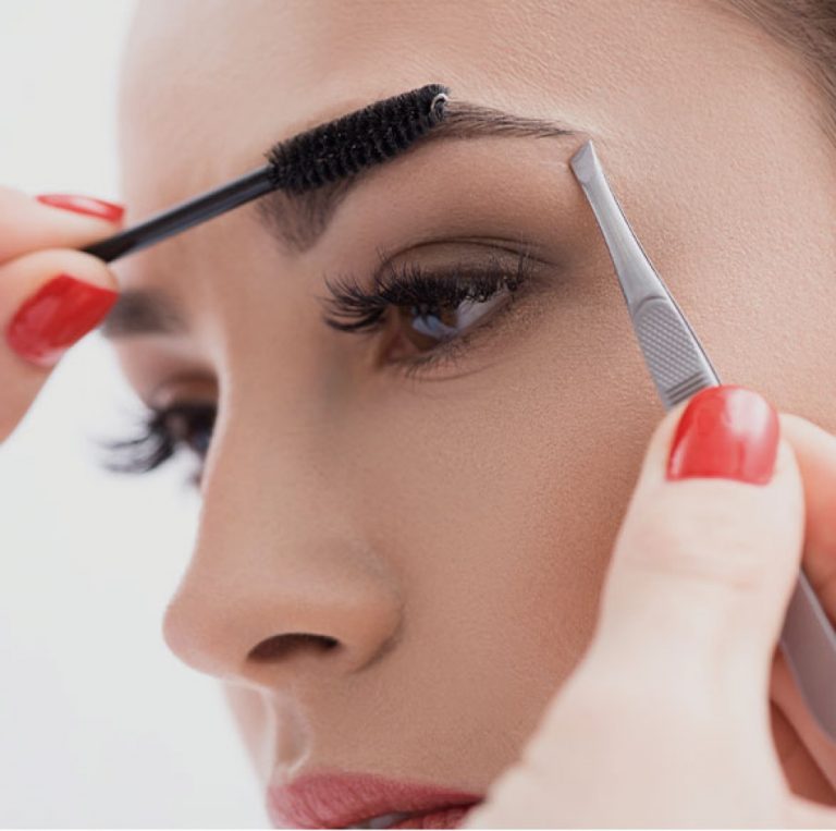 woman having her brows at lashes done by a beautician